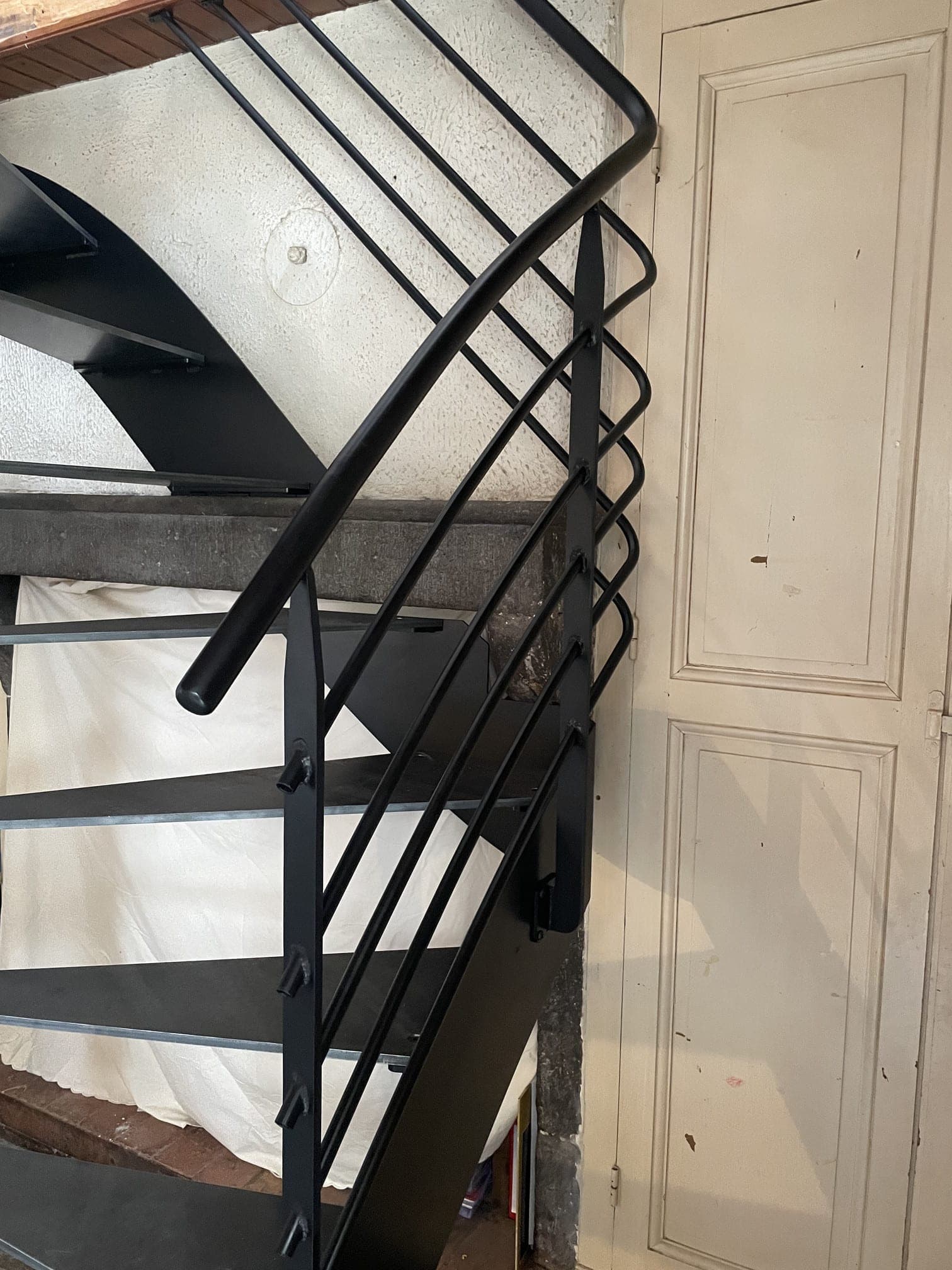 Détail du garde-corps : main courante en tube rond, lisses rondes et montants en fer plat