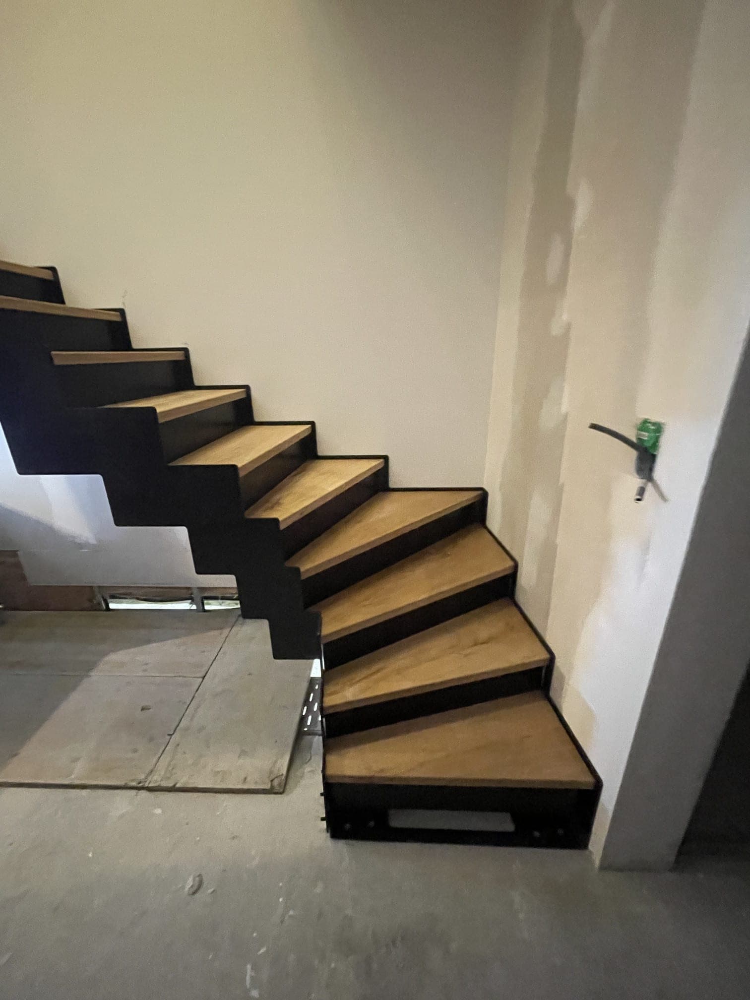 Départ balancé de l’escalier : marches en chêne tournant d’un quart, première marche en caisson acier