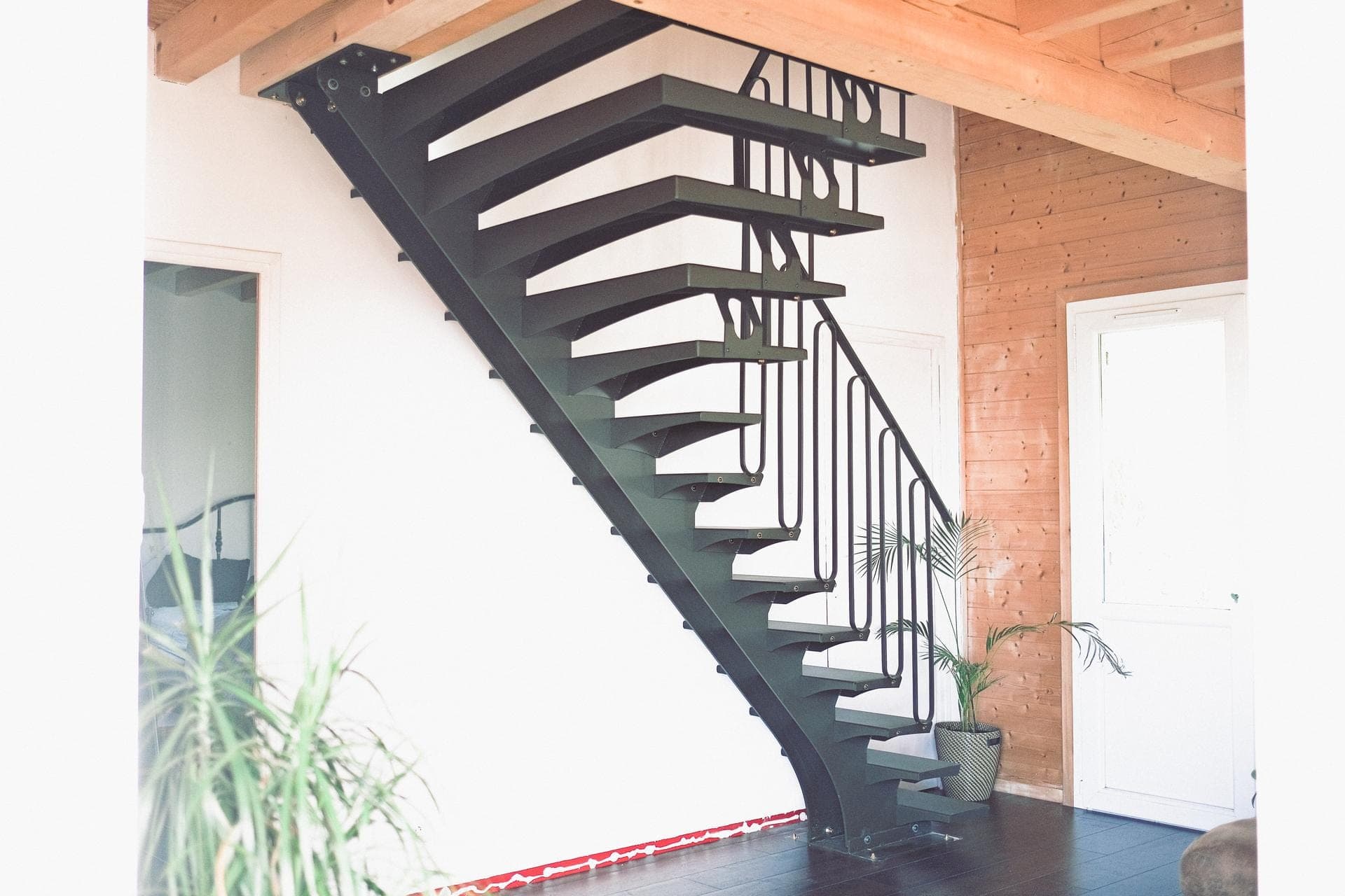 Vue d’ensemble de l’escalier droit en acier noir, limon central et garde-corps en épingles, dans un intérieur bois