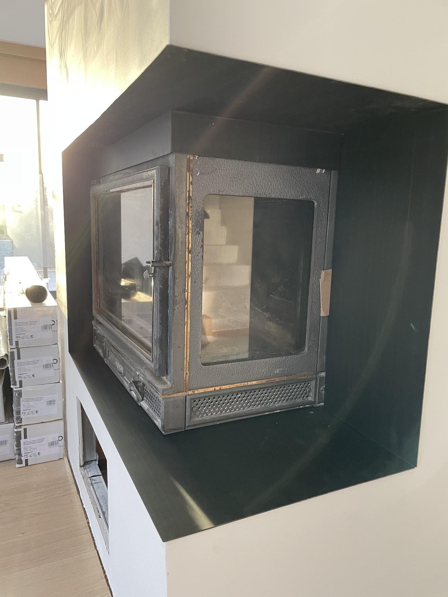 Vue rapprochée de la niche en acier noir habillant l’insert à deux faces vitrées.