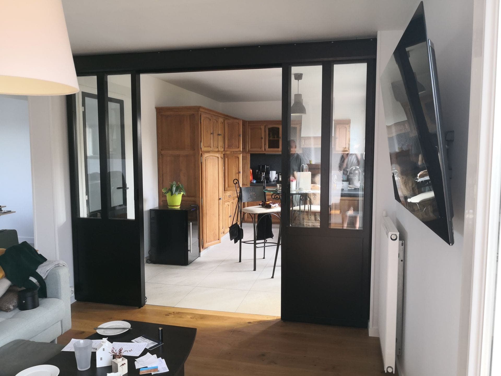Les deux portes coulissantes ouvertes dégagent le passage entre le salon et la cuisine